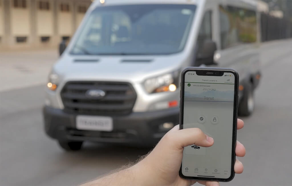 Tela de um celular exibindo o app Ford, com Ford Transit ao fundo