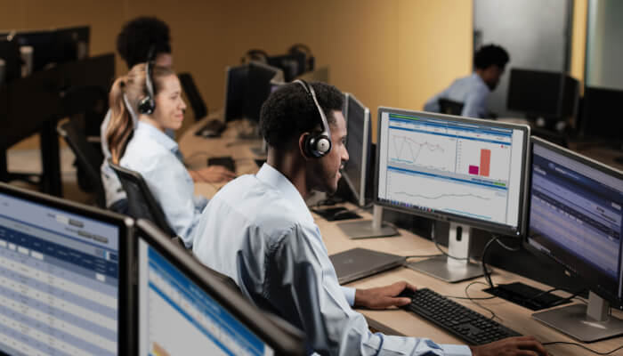 Sala de atendimento call-center com vários atendentes e computadores