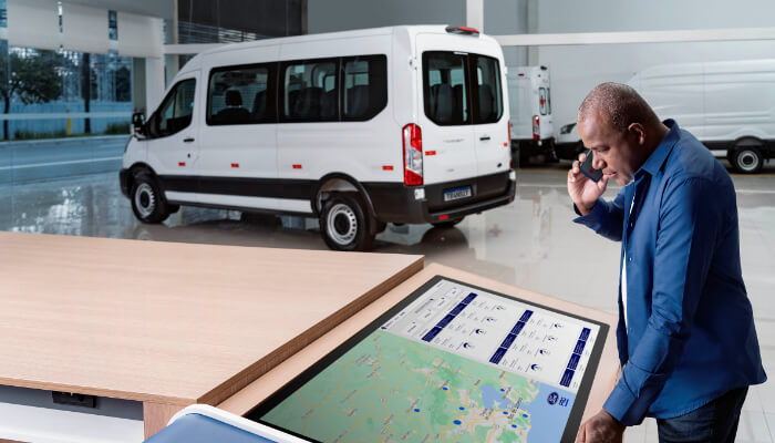 Conectividade Homem falando ao celular e consultando mapa e Ford Transit Minibus