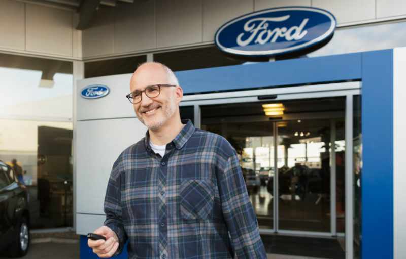 Kunde hält Schlüssel für Ersatzwagen in Hand