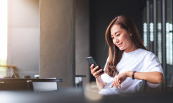 Frau sitzt mit Smartphone
