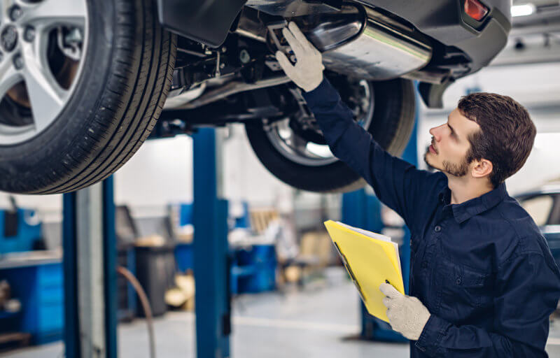 Mechaniker inspiziert Fahrzeug Carosserie