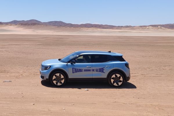 Charge Around the Globe Ford Explorer su strada in un paesaggio desertico con Lexie Limitless