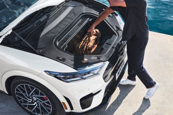 Una persona solleva una borsa dal bagagliaio di un veicolo Ford