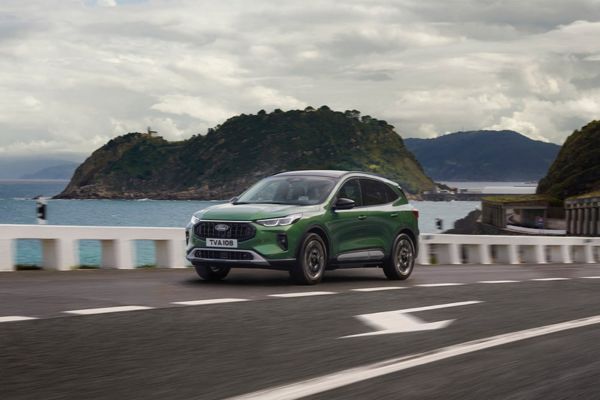 Grüner Ford Kuga steht auf Parkplatz und blickt auf Stadt