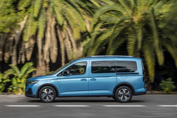 La Tourneo Connect bleue roule sur une route bordée de palmiers