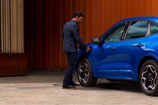 La Ford Kuga bleue est chargée par un homme