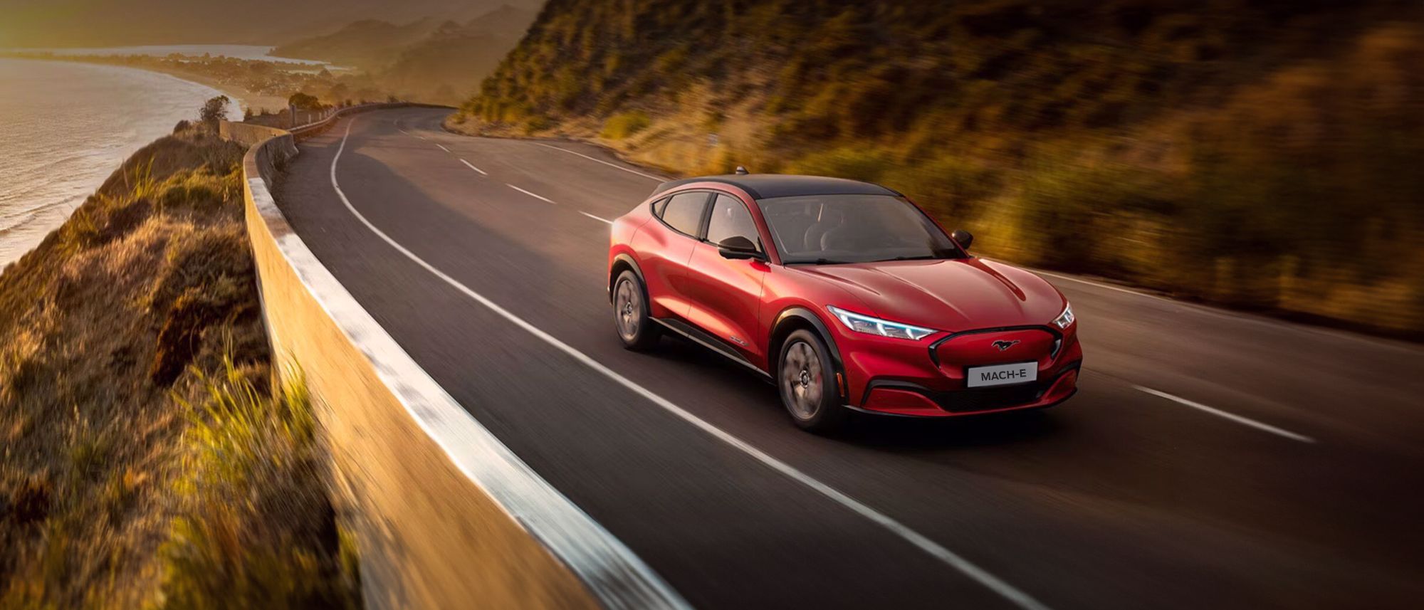 Ford Mustang Mach-E rouge roulant au coucher du soleil