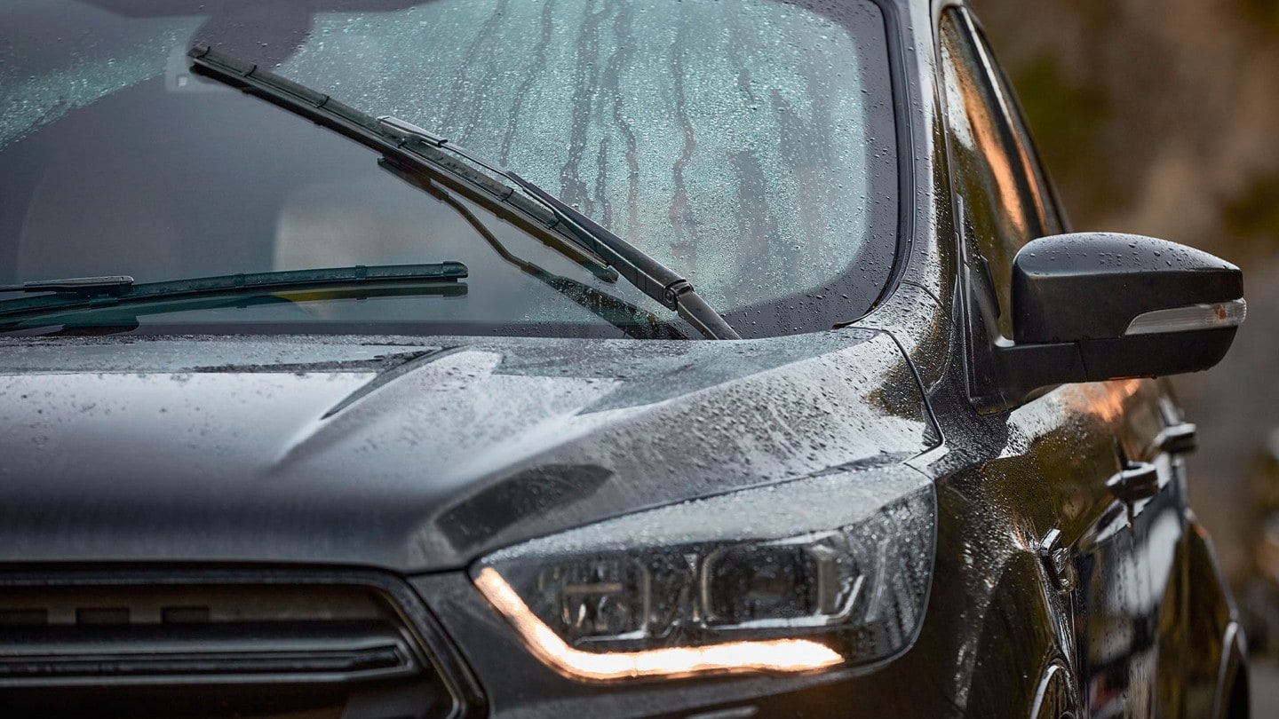 Voiture roulant sous la pluie avec vue sur feu avant