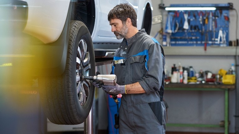 Technicien Ford serrant des boulons de roue